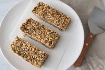 Close up of three home made granola bars on a white plate.