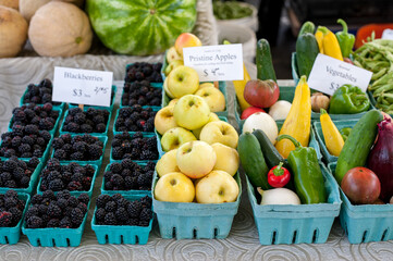 Fresh produce for sale including blackberries, apples, and assorted vegetables.