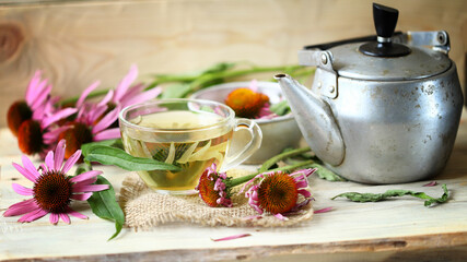 Selective focus. Echinacea tea in a cup. Echinacea flowers. Teapot and a cup of tea.