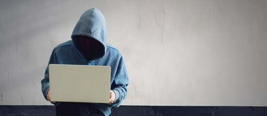 anonymous hacker person in the hood with computer, digital information breaking