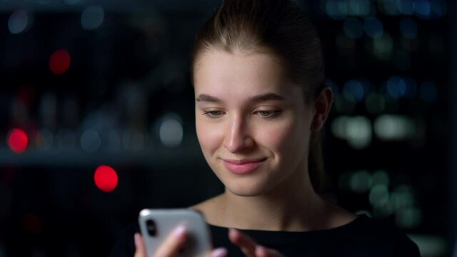 Portrait of smiling girl touching screen of mobile phone.Surfing internet .