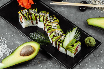 Green dragon sushi roll with eel, avocado, cucumber and ginger, accompanied with fried tempura shrimp. Traditional asian rice sushi healthy seafood © Дмитрий Скорина