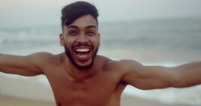 Friendly young Latin American man inviting to come to Brazil, confident and smiling making a gesture with his hand, being positive and friendly. Beach from Brazil. 4K.