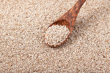 Seeds Chia white in wooden spoon on grains background. Selective focus, copy space