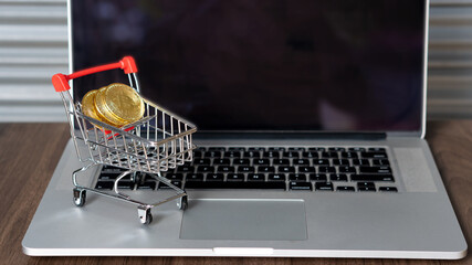 Bitcoin coins in the basket and laptop Stock market concept