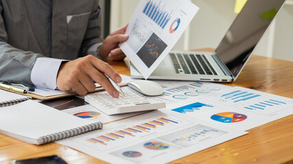 Business people doing business in finance and calculating calculators and analyzing graphs about...