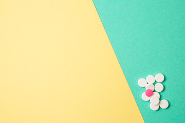 White and pink medicines on a colored background