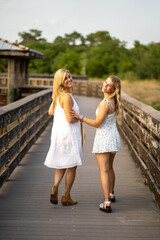 Two blonds on boardwalk looking over their shoulder