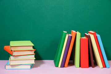 Composition with vintage old hardback books, diary, fanned pages on wooden deck table and colored background. Books stacking. Back to school. Copy Space. Education background.