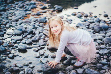 Girl playing with stones on a mountain river
