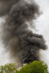 black smoke trail of burning house