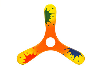 3 wings wooden boomerang painted orange, and yellow with color splash, isolated on white background, center hole for finger catching - obrazy, fototapety, plakaty