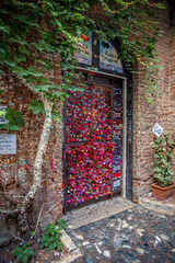 Verona, Italy, 07.04.2019: view of the door with love notes and padlocks located at Juliet's house...