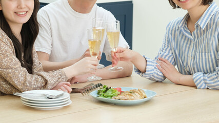 ダイニングでホームパーティーをする若い男女