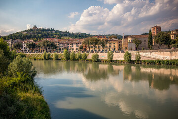 Fototapeta na wymiar Verona, Italy, 07.04.2019: view from the bank of Adige River to Hilltop church, former fort Santuario della Nostra Signora di Lourdes