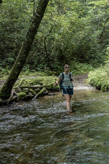 Fototapeta na wymiar Woman Crosing Shin Deep Creek