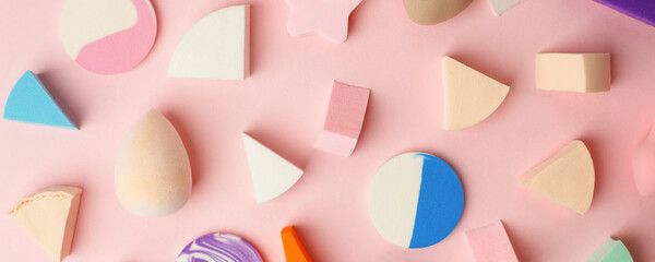 Naklejka premium Set of Cosmetic colorful sponges on pink background, copy space, beauty, difference concept, Cosmetology tools for make up artists, visage, beutician industry banner, abstract, copy space