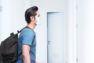 Fototapeta na wymiar Asian man in the face mask with a backpack on the hospital