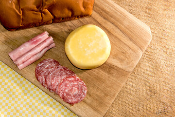 Colonial breakfast served with bread, cheese, ham and salami. Top view.