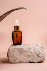 Fototapeta na wymiar The bottle of Essence is on the pedistal. Lotion on a Beige background. Cosmetics for skin health. Aromo Oil. Serums with vitamin C. Unisex cosmetics. Mockup. 