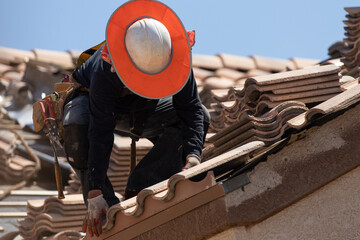 construction worker on the roof of a house