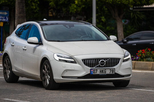 Alanya, Turkey  &ndash; April 12 2021:  white Volovo V40 is driving fast on the street on a warm summer day against the backdrop of a  palms