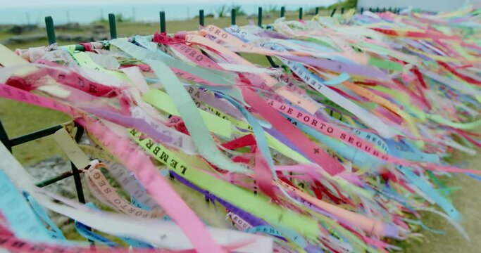 Closeup of colorful ribbons in Bahia, Brazil. Man hand making an request with Brazilian ribbons. Faith. 6K.