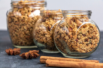 Freshly baked granola, muesli from oat flakes, varius of nuts, honey, pumpkin seeds in glass jar. Home cooking healthy vegetarian snack. Homemade food concept. Keto diet.