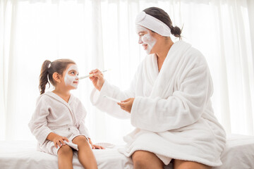Obraz na płótnie Canvas dia de Spa mama e hija con mascarilla blanca y fondo blanco