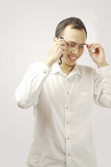 Portrait of Confident young man in white t-shirt while standing against gray background. 