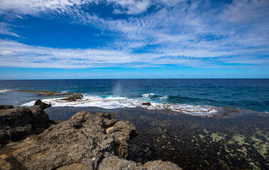 Fototapeta na wymiar Coastal rock blowholes, a popular tourist site on the main island of Tonga, on a beautiful sunny day.