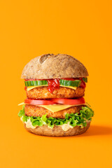 Vegan burger close-up isolated on an orange background.