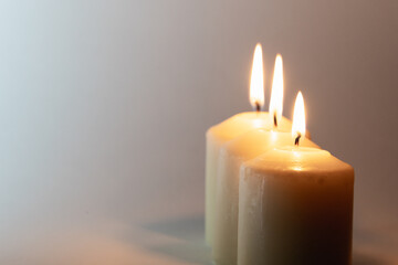 Fototapeta na wymiar Three lighted candles on a white background