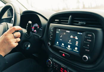 Car Multimedia System Panel with female driver's hand