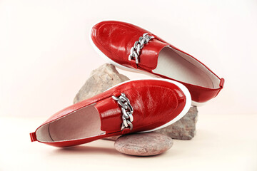 Fashion and stylist concept. Red loafers, boots or moccasins on a stone podium on a neutral...