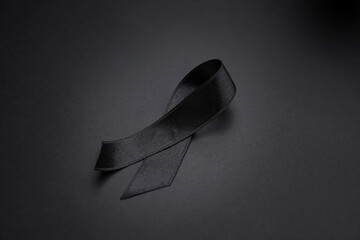 Black funeral ribbon on dark background