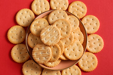 Bowl with tasty crackers on color background