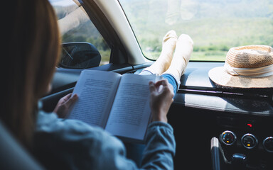 A woman reading book while riding the car