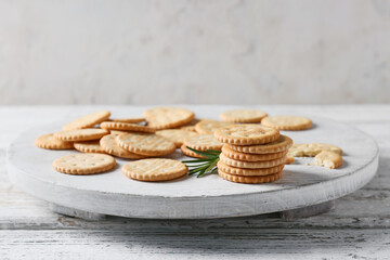 Board with tasty crackers on light wooden background