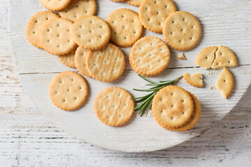 Board with tasty crackers on light wooden background