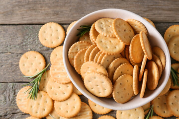 Bowl with tasty crackers on wooden background