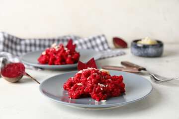 Plates with tasty beet risotto on light background