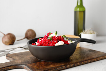 Frying pan with tasty beet risotto on light background