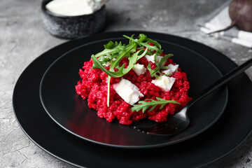 Plate with tasty beet risotto on grey background