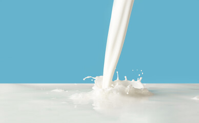 Pouring of tasty milk on color background