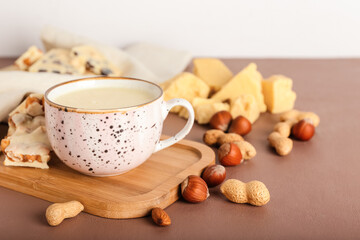 Cup with hot white chocolate on color background