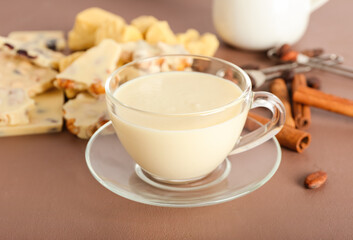 Cup with hot white chocolate on color background