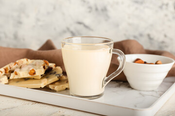 Cup with hot white chocolate on light background