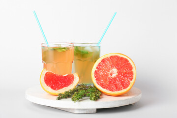 Glasses of tasty grapefruit lemonade on white background