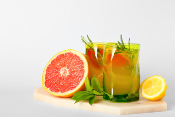 Glasses of tasty grapefruit lemonade on white background